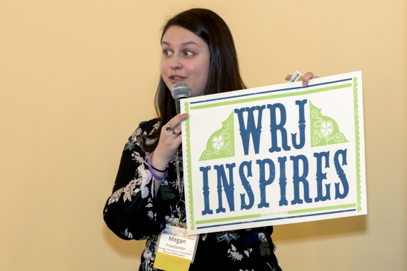 Woman holding a sign that says WRJ Inspires