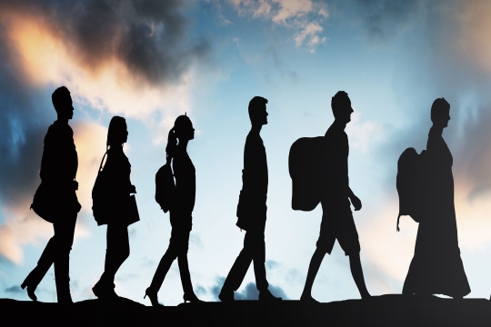 six silhouetted people walking with clouds behind them